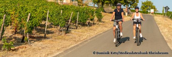 Ein Paar radelt unterhalb der Kreuzkapelle am Wissberg durch die Weinberge - Foto von Dominik Ketz/Mediendatenbank Rheinhessen